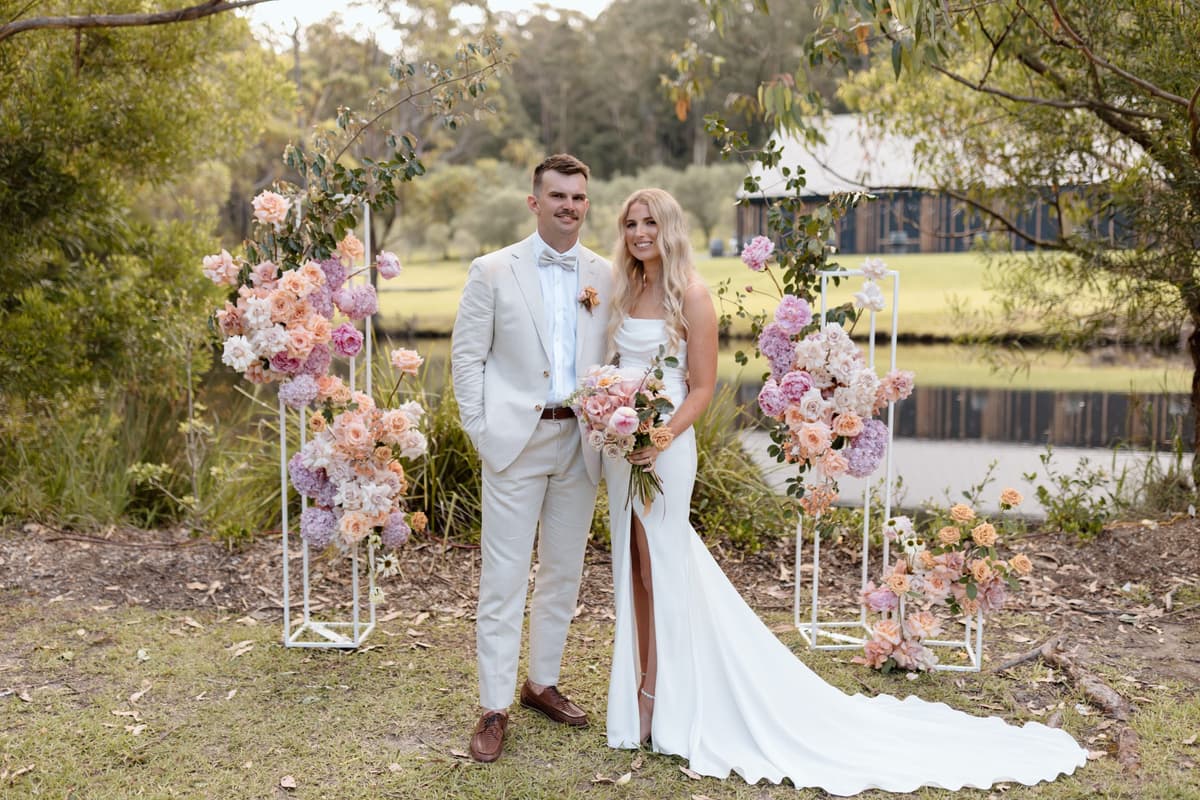 Ceremony beneath a floral arch on the lawn